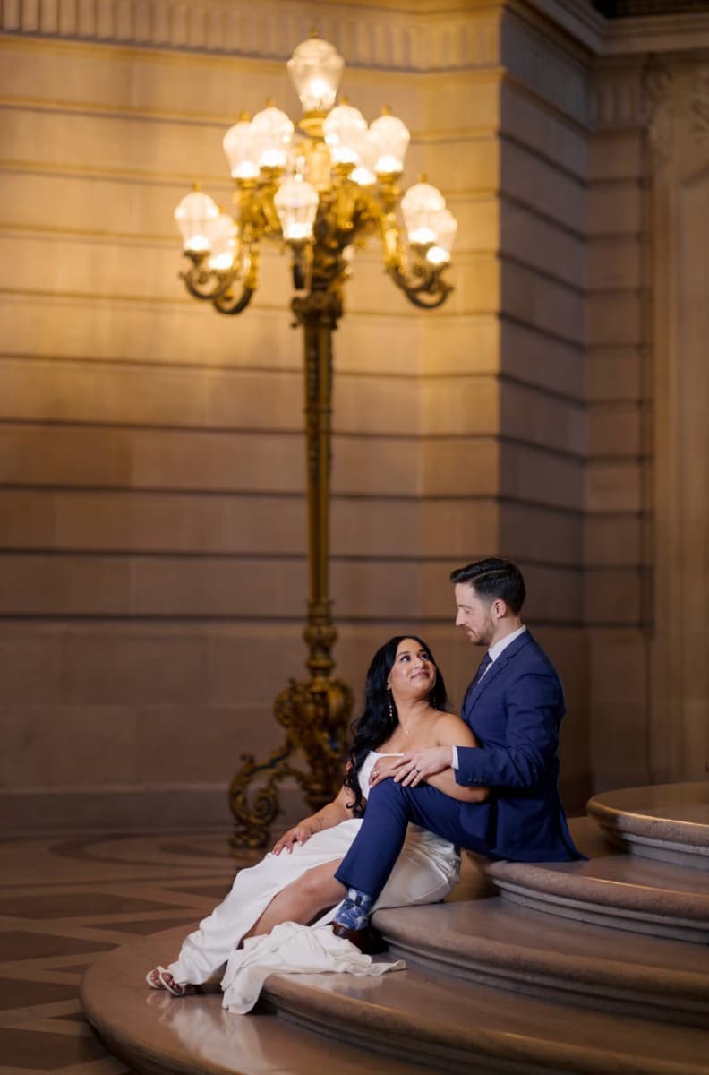 Elegant couple in formal attire with ornate lighting